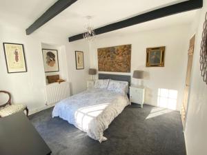 a bedroom with a bed and a painting on the wall at The Old Smithy in Ventnor