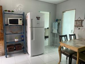 a kitchen with a white refrigerator and a table at Duplex agradável com Ar, Internet, Netflix e Estacionamento in Campina Grande