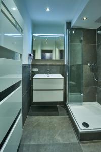 uma casa de banho com um chuveiro, um lavatório e um chuveiro em Atlantic 05 em Grömitz