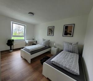 a bedroom with two beds and a window at Living Flat, eine Wohnung mit zwei Schlafzimmern und Balkon in Schorndorf