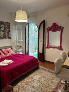 - une chambre avec un lit rouge et un miroir dans l'établissement Casa Patrizia, à Giardini Naxos