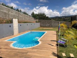 a swimming pool in a yard next to a fence at Recanto do sol in Extrema