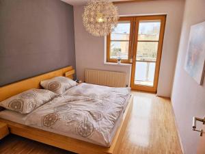 a bedroom with a large bed with a chandelier at Etagenwohnung mit Garten in Vöcklabruck