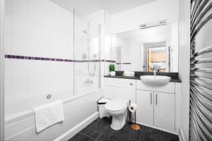 a white bathroom with a toilet and a sink at Birmingham City Centre Deluxe Apartment - Top Rated - 36C in Birmingham