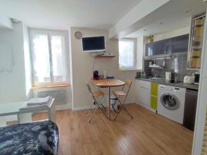 una piccola cucina con tavolo e una lavanderia di Studio Hypercentre Fontainebleau , Proche Château a Fontainebleau Altre 3 foto