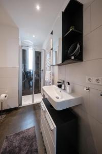 a white bathroom with a sink and a shower at Gray Dream I stilvoll und neu in Hannover