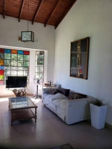 sala de estar con sofá y TV en Quinta Oasis de Paz en Los Cardales en Campana