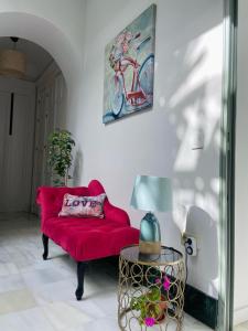 a living room with a red couch and a picture of a bike at La Gitanilla Alojamiento & Encanto Jerez in Jerez de la Frontera