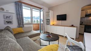 a living room with a couch and a table at Ferienwohnung Edeltraud, fußläufig zum See und 20 Minuten vom Skigebiet entfernt in Döbriach
