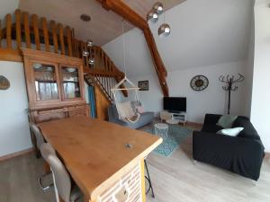 a living room with a wooden table and a couch at LeS GITES CAMBOIS in Cambes