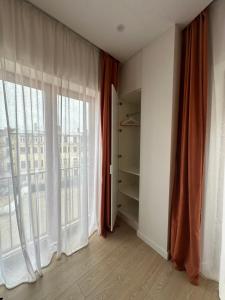 um quarto vazio com uma grande janela com cortinas em Dzīvoklis Vecrīgas sirdī em Riga