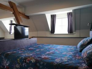 a bedroom with a bed and a flat screen tv at B&B Catharinenburg in Melissant