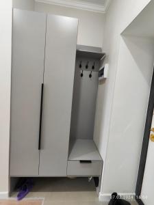 een witte kast met zwarte knoppen in een kamer bij Tandau apartment in Taldykolʼ +11 foto's