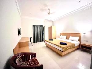 een slaapkamer met een bed en een stoel erin bij Morjim Sunset Guesthouse - 300 meter to Morjim Beach in Morjim
