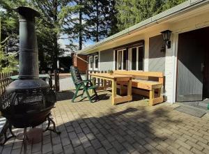 een huis met een houtkachel en een picknicktafel bij Waldhütte Allzunah in Ilmenau