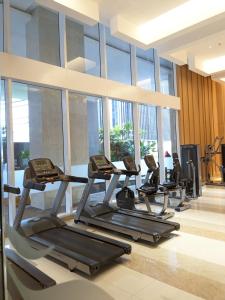 a row of treadmills in a gym with windows at The cozy & luxury room in Podomoro City Deli Medan in Medan