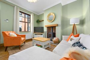 a living room with a white couch and a fireplace at 2-Bedroom Cottage - Long Stays Welcome in Cheadle +22 photos
