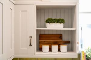 a cupboard with a pot and a plant in it at 2-Bedroom Luxury Cottage - Long Stays in Cheadle