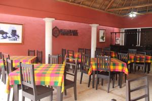 a dining room with tables and chairs with colorful table cloth at Hotel Turquesa Maya in Felipe Carrillo Puerto