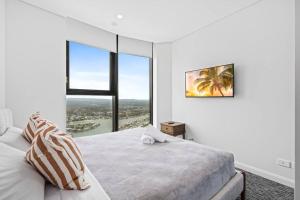 Ένα ή περισσότερα κρεβάτια σε δωμάτιο στο Luxe Canal View APT in Surfers Steps from the Sea +5 φωτογραφίες