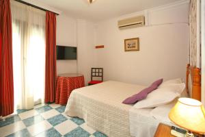 a hotel room with a bed and a window at Pension Zurita in Granada