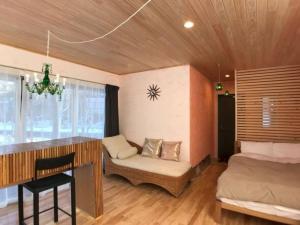 1 dormitorio con cama, escritorio y silla en Kitakaruizawa Morino Bessou NO9, en Tsumagoi