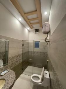 British Hotel - Johar Town LHR في لاهور: حمام مع دش ومرحاض ومغسلة