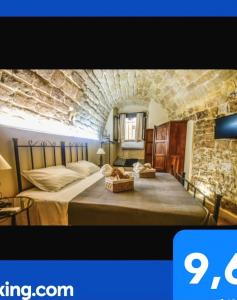 um quarto com uma cama numa parede de pedra em Domum in petra casa nella roccia Self check - in em Modica