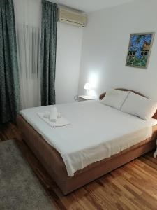 a bedroom with a large white bed with two candles on it at House Leana Herceg Novi in Herceg-Novi