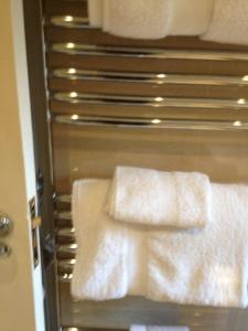 a towel rack with white towels in a bathroom at Ferienwohnung in einer Villa mit herrlichem Garten und Katze in Sydenham