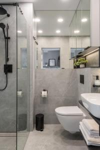 a bathroom with a shower and a toilet and a sink at AVAPARTS Apartament AQUA in Jastarnia +16 photos