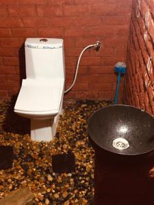 - une salle de bains pourvue de toilettes et d'une poubelle dans l'établissement Bamboohutz, à Auroville