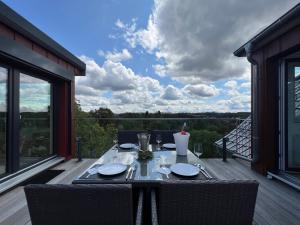 a table on the deck of a house with a view at Braunlage Lodge in Braunlage