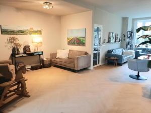 a living room with a couch and a tv in it at Zee-en-Zo Noordwijk in Noordwijk