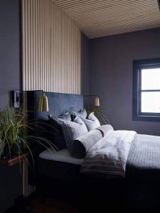um quarto com uma cama com almofadas em Lofoten Fyr em Værøy