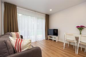 a living room with a couch and a table at KUTI apartamentai in Palanga