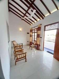 salon z 2 krzesłami i oknem w obiekcie Jasmine Apartments w Negombo