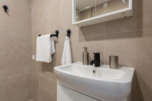 a bathroom with a white sink and a mirror at KUTI apartamentai in Palanga +24 photos