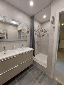 uma casa de banho com um lavatório, um chuveiro e uma banheira em Les appartements sur Pompidou - 7 appartements neufs société selogerametz com em Metz