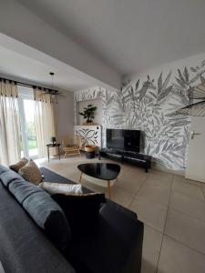 uma sala de estar com um sofá e uma televisão em Les appartements sur Pompidou - 7 appartements neufs société selogerametz com em Metz