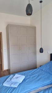 a bedroom with a blue bed with white cabinets at Dwie Mewy 2 in Mrzeżyno
