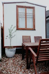 un tavolo in legno e 2 sedie accanto a una finestra di Cozy & Thoughtful Tiny Home a Kallangur