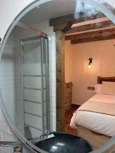 Baño con espejo junto a una cama y bañera en El Capricho de la Serranía I en Tragacete