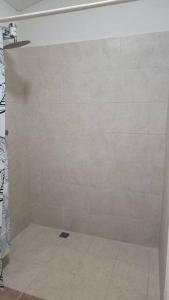 a shower stall in a bathroom with a tile floor at Welcome to our 1 bedroom villa in Bridgetown