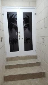 a white door in a room with stairs at Welcome to our 1 bedroom villa in Bridgetown