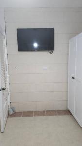 a bathroom with a flat screen tv on the wall at Welcome to our 1 bedroom villa in Bridgetown