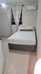 a small bedroom with a bed in a room at Welcome to our 1 bedroom villa in Bridgetown