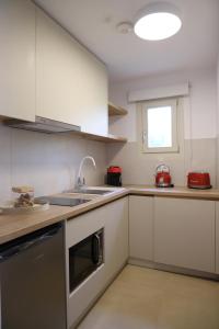 a kitchen with white cabinets and a sink at Castrusso Castle apartments in Chios