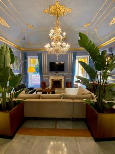 a living room with a couch and a chandelier at Palazzo Cherubini - Wellness e Spa in Rossano