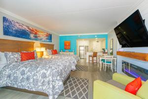 a bedroom with a bed and a television and a kitchen at Immaculate Ocean View Double Queen Suite! Beautifully Upgraded!-Grande Cayman Unit 316 in Myrtle Beach